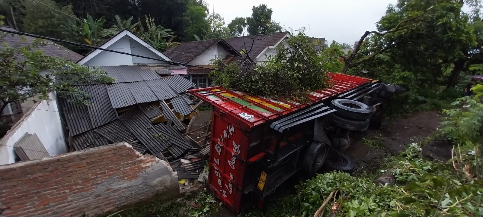 Truk fuso asal Pemalang Jateng alami rem blong di Jalur Gumitir Jember hingga menabrak pohon dan terguling di halaman rumah warga.