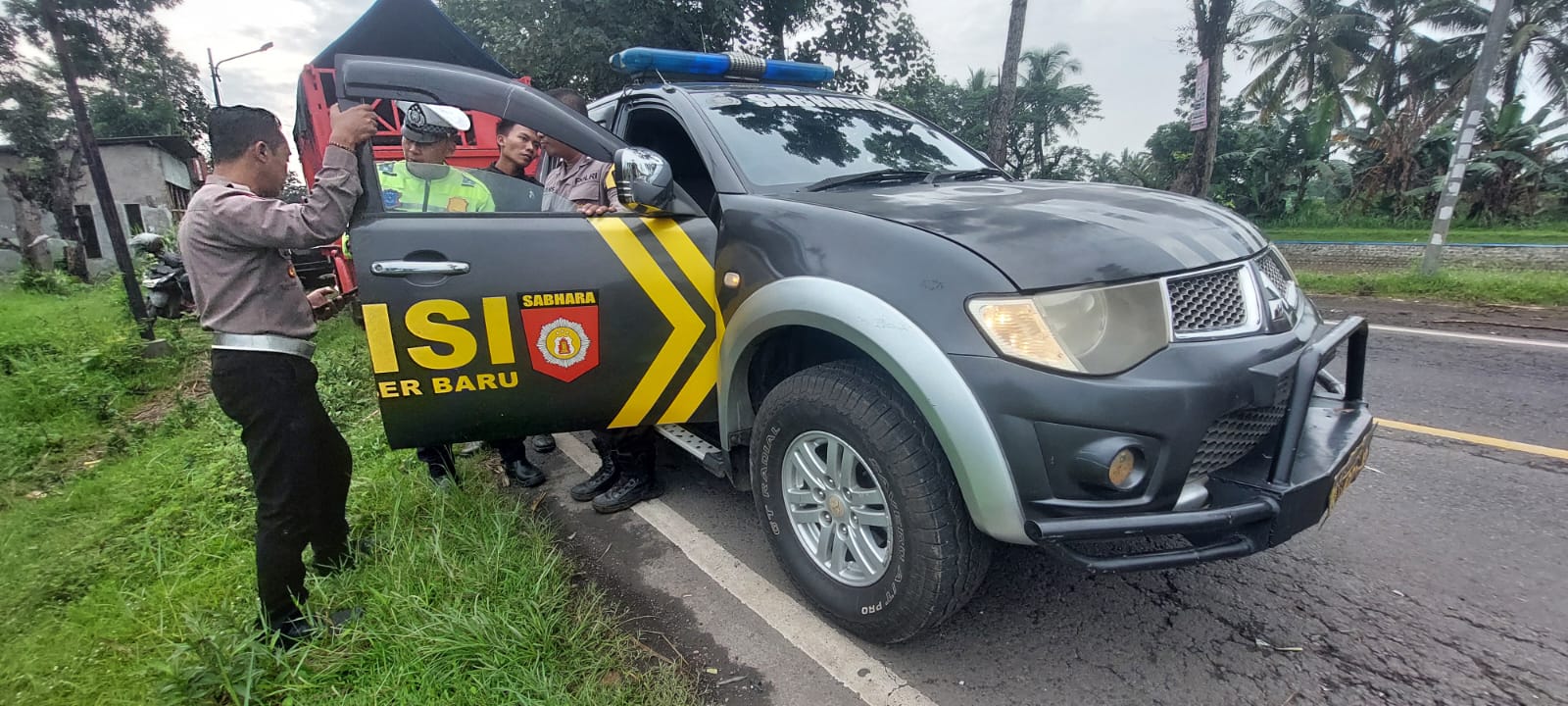 Anggota Polsek Sumberbaru memeriksa Mobil patroli setelah insiden pelemparan Batu oleh pembalap liar.