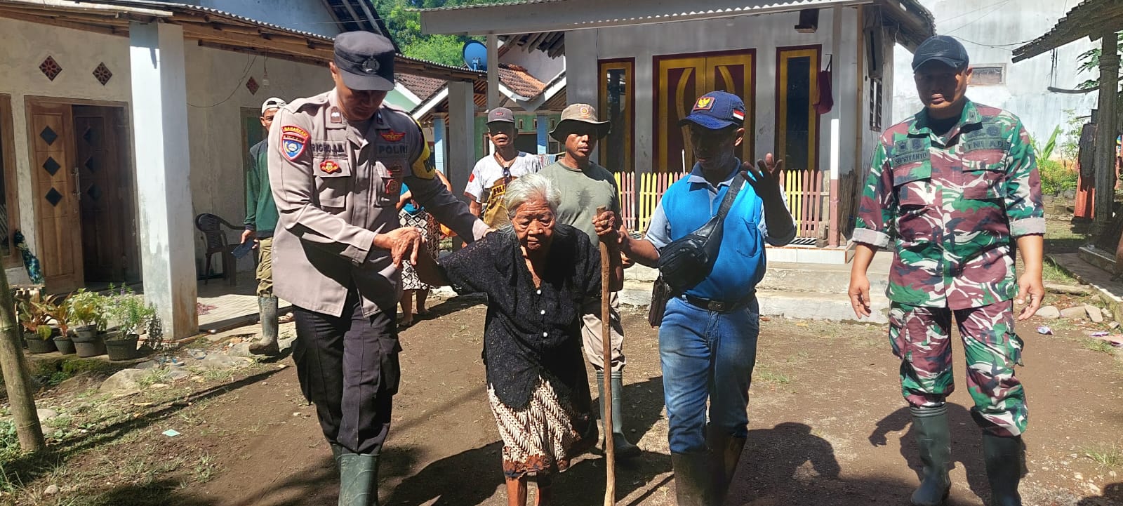 Nenek Turi (tengah) dievakuasi petugas dan perangkat desa ke tempat yang lebih aman agar terhindar dari banjir bandang susulan di Panti.