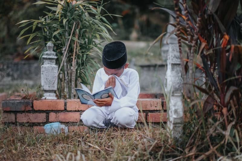 Seorang anak ziarah kubur atau nyekar. (Foto: f&uuml;r&ucirc;zan-pinterest)