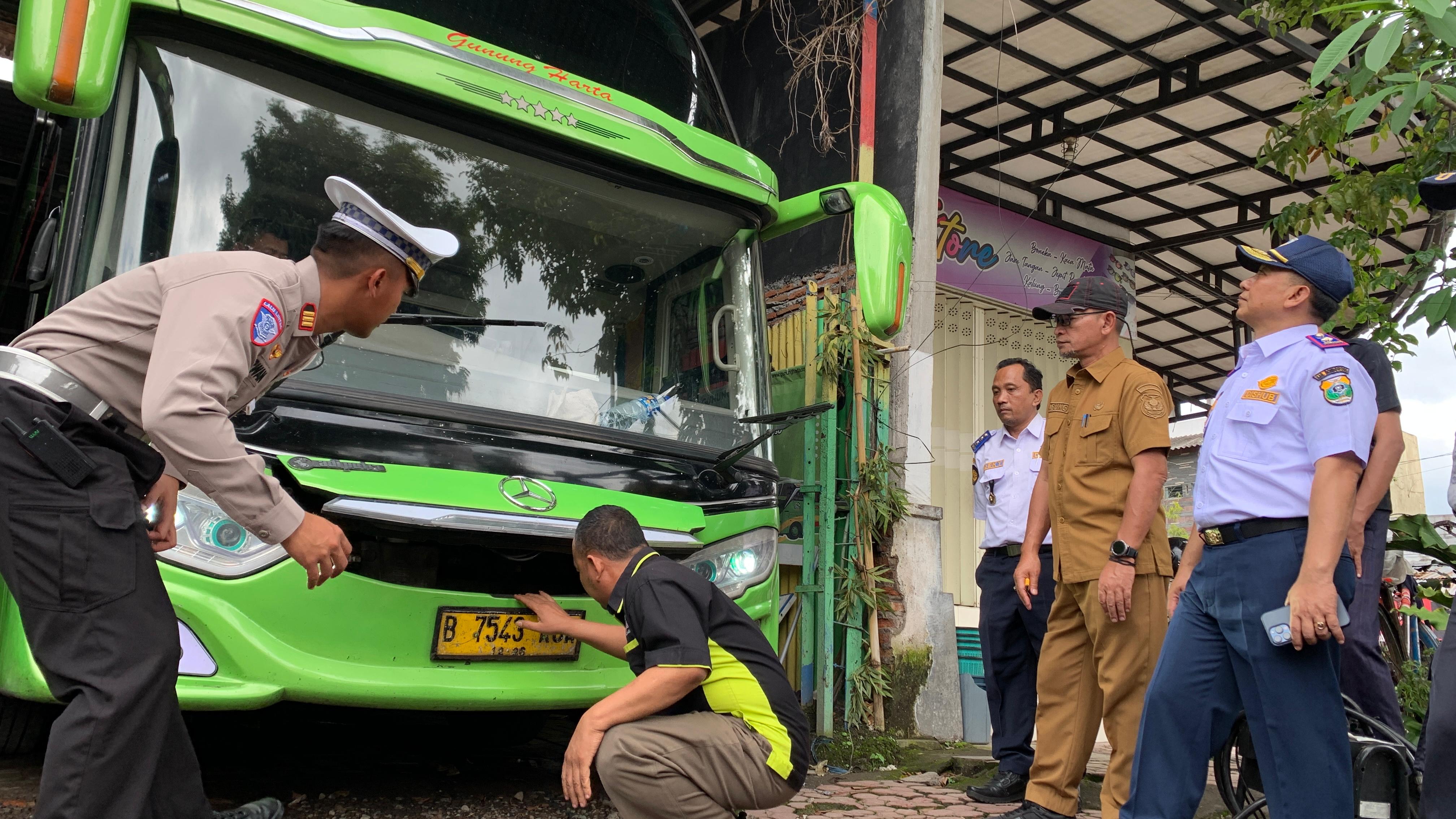 PENGECEKAN: Petugas gabungan dari Dishub dan Satlantas Polres Bondowoso memeriksa armada angkutan tahun baru beberapa waktu lalu. (ILHAM WAHYUDI/RADAR IJEN)