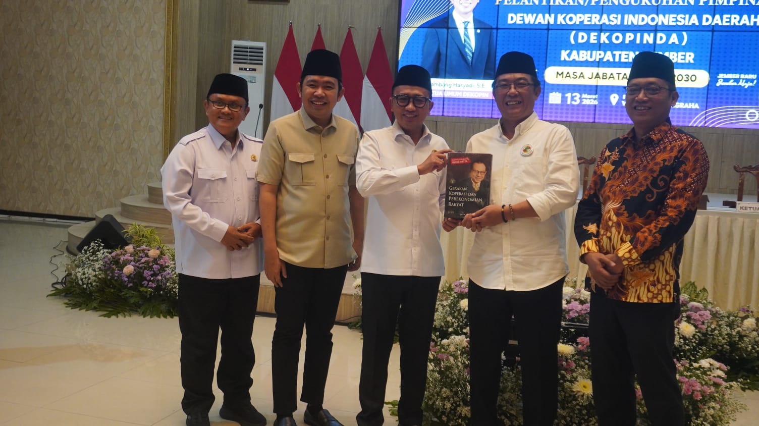 Ketua Umum Dekopin Bambang Haryadi (tengah) menyerahkan buku kepada Ketua Dekopinda Jember Ardi Pujo Prabowo