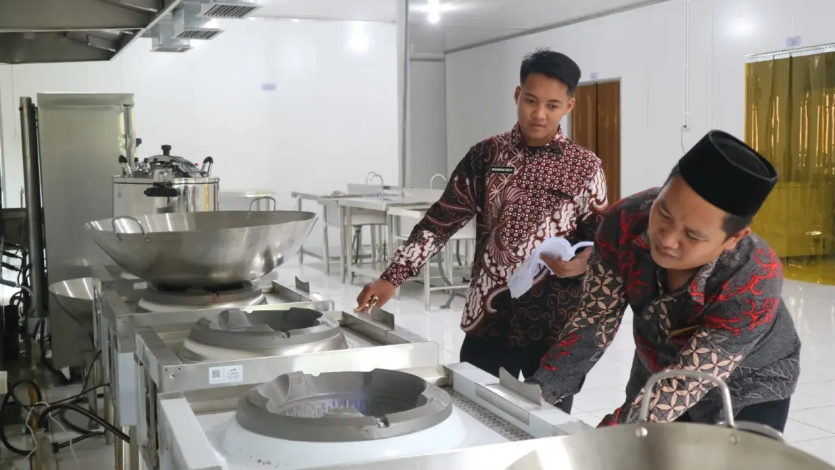 Petugas SPPG memeriksa kompor di dapur gizi. Selama libur Lebaran 2026, program MBG tetap jalan dan tersalurkan. Ini penjelasan BGN. (Sidkin/Halojember)