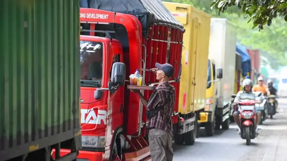Kemacetan parah terjadi di jalan Wongsorejo – Pelabuhan Ketapang Banyuwangi dan moment antrean panjang yang mengular puluhan Km ini dimanfaatkan penjual es keliling. (Ramada Kusuma/Radar Banyuwangi)