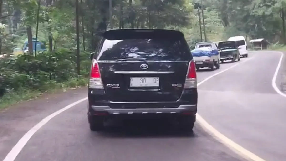 BAGAIMANA INI: Kendaraan dinas milik Pemkab Banyuwangi bernopol P 30 QP yang seharusnya plat merah berubah jadi plat putih, melintas di Jalur Gumitir, Selasa 7 April 2026. (JUMAI/RADAR JEMBER)