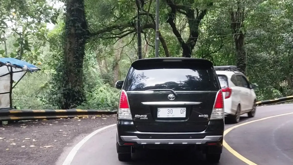 BAGAIMANA INI: Kendaraan dinas milik Pemkab Banyuwangi bernopol P 30 QP yang seharusnya plat merah berubah jadi plat putih, melintas di Jalur Gumitir, Selasa 7 April 2026. (JUMAI/RADAR JEMBER)