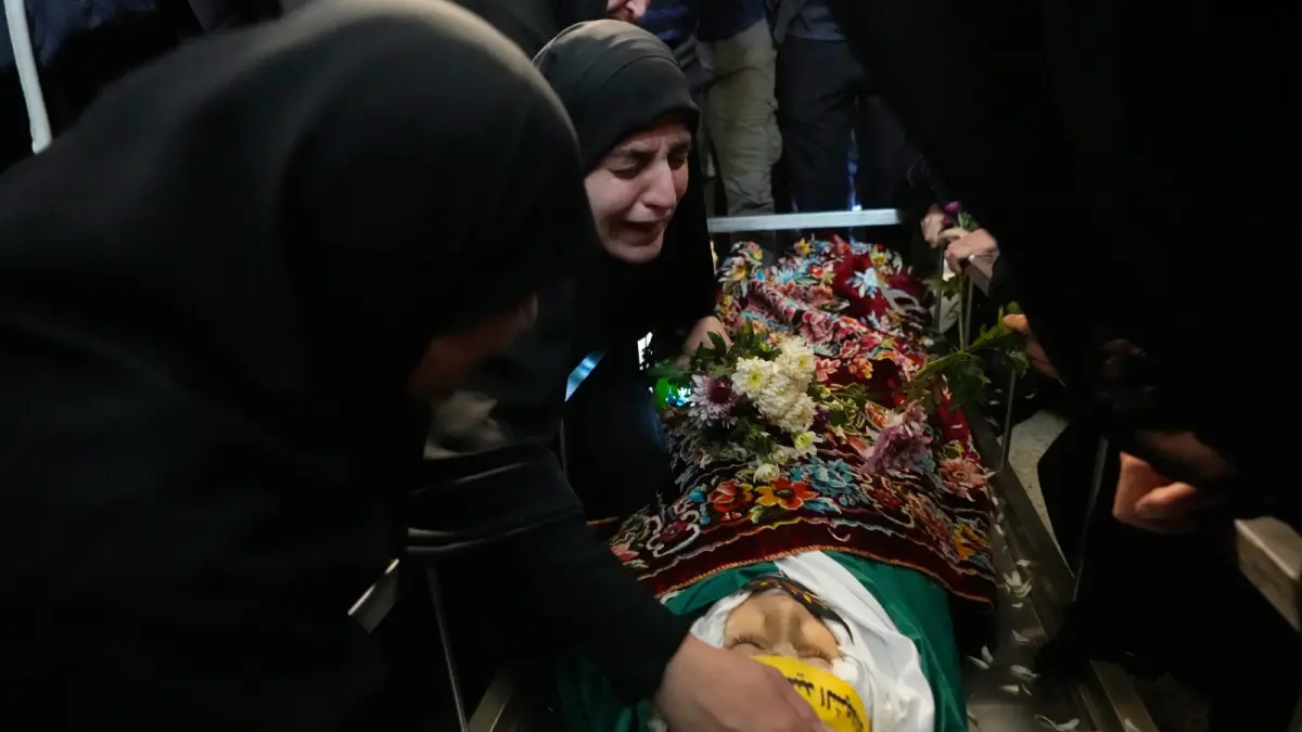 Malak Meslmani, center, the mother of Jawad Younes, 11, who was was killed in an Israeli airstrike, mourns over her son’s body during his funeral procession in Saksakieh village, south Lebanon, Saturday, March 28, 2026. (AP Photo/Hussein Malla, File)