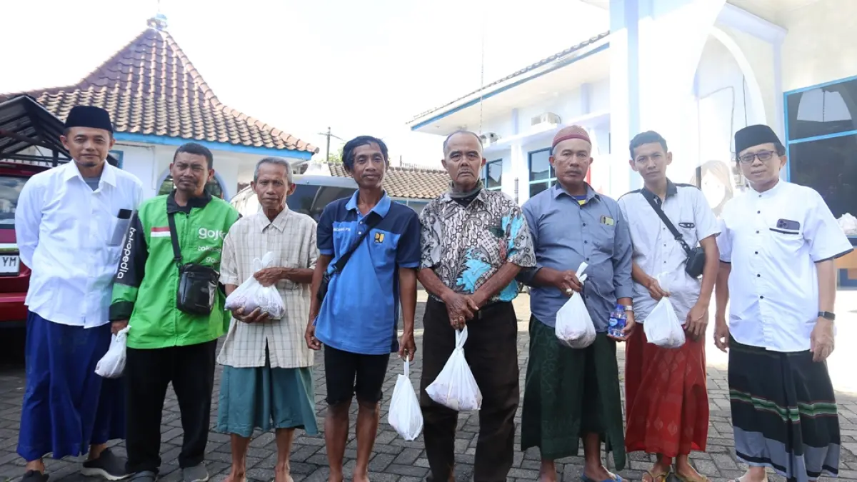 Direktur Jawa Pos Radar Jember A Choliq Baya dan GM Radar Jember MS Rasyid memberikan daging kurban kepada para loper. (yulio fa/halojember)