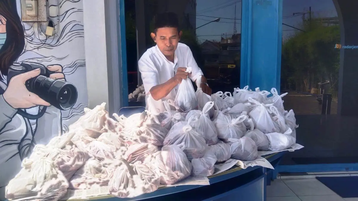 Wartawan senior Jawa Pos Radar Jember menata daging sapi yang diap dibagikan kepada karyawan dan loper. (nurhariri/halojember)