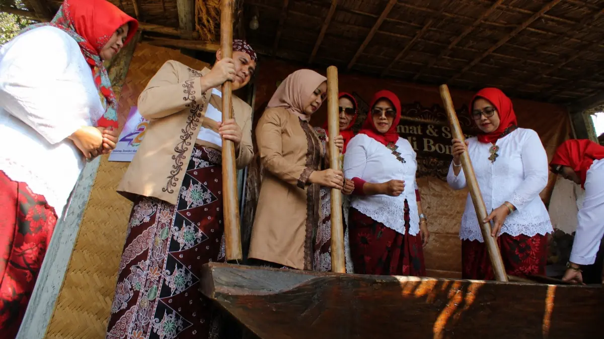 FOKUS: Sejumlah ibu-ibu asik memukul lesung kayu yang memunculkan sebuah irama. (FAQIH HUMAINI/HALO JEMBER) 

