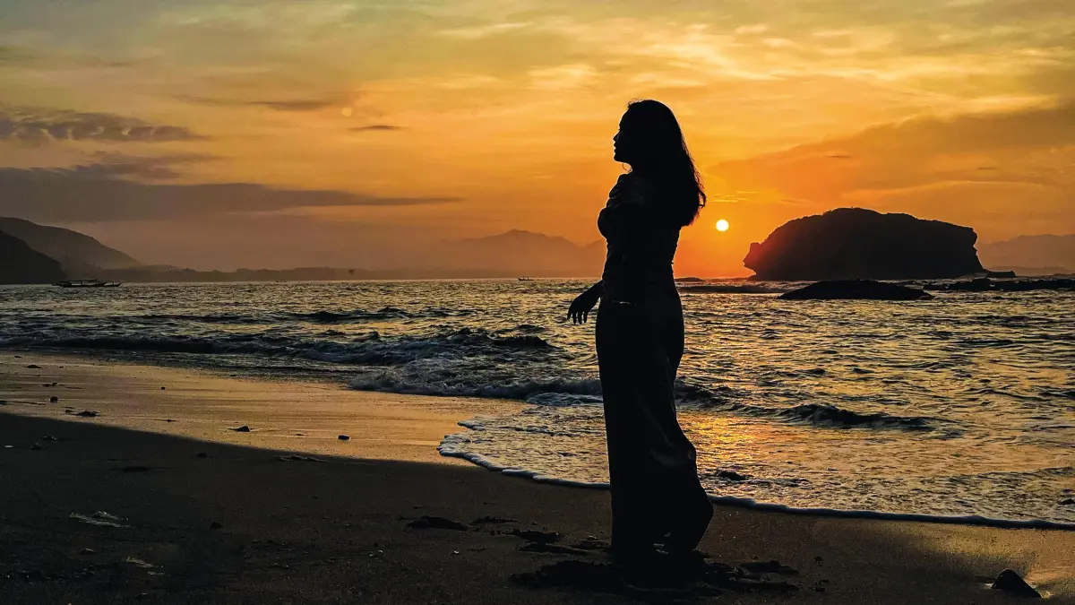 MENAWAN: Wisatawan mengabadikan foto berlatar belakang matahari terbit atau sunrise di Pantai Papuma Jember (GESHEILA/HALO JEMBER)