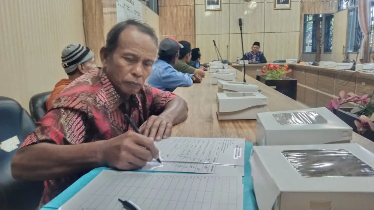 Salah satu anggota Sekti mengisi daftar hadir dalam hearing terkait Agraria di ruang Komisi A DPRD Jember. (nurhariri/halojember)