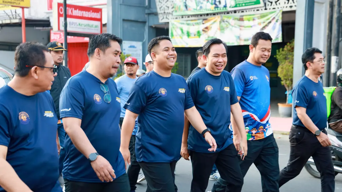 KOMITMEN BERSAMA: Bupati Jember Gus Fawait bersama Wanen P2MI Dzulfikar Ahmad Tawalla, saat jalan sehat Gerakan Nasional Migran Aman, bersama ribuan masyarakat, di Alun-alun Jember, Minggu (14/6).
