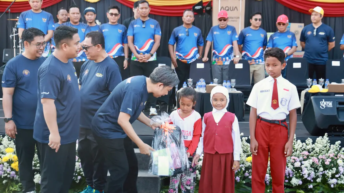 LINDUNGI KELUARGA PMI: Bupati Gus Fawait bersama Wanen P2MI Dzulfikar Ahmad Tawalla, simbolis menyerahkan beasiswa bagi anak keluarga pekerja migran, saat rangkaian Gerakan Nasional Migran Aman, di Alun-alun Jember, Minggu (14/6).