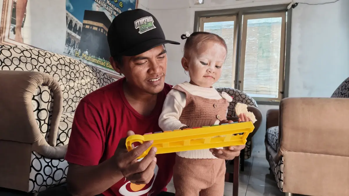 MAIN BERSAMA: Ali Arizan saat menemani sang anak bermain alat musik. (FAQIH HUMAINI/HALOJEMBER)
