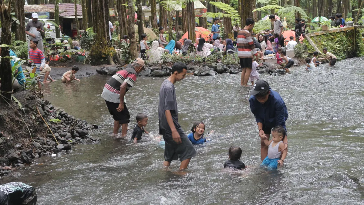 PUAS: Anak-anak asik bermain bersama orang di sungai yang ada di Candipuro, Lumajang. (ADE APRYANIS/HALOJEMBER)