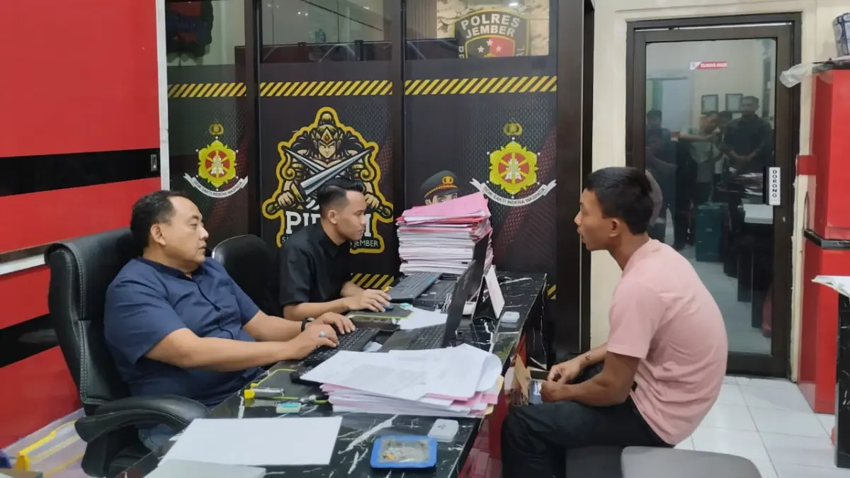 AB saat menjalani pemeriksaan di Satreskrim Polres Jember seusai kedoknya menyamar sebagai anggota Polri terbongkar , Selasa (21/7/2026). (Syakur)