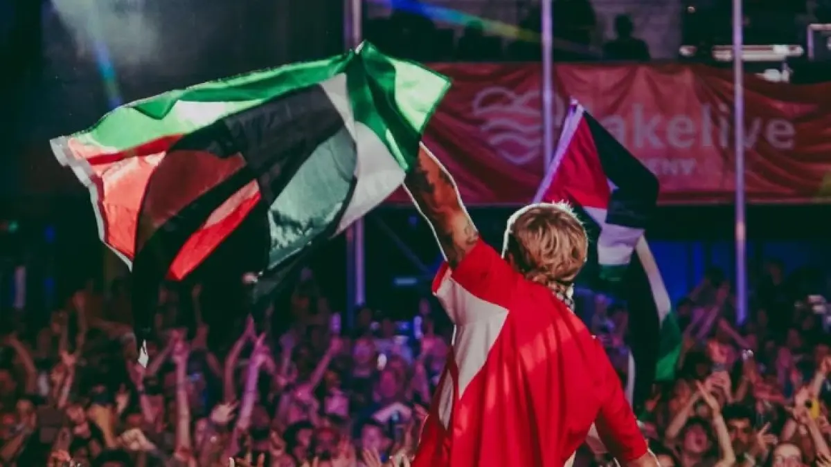 Macklemore memegang bendera Palestina pada tur konser di Switzerland (Instagram @/macklemore)