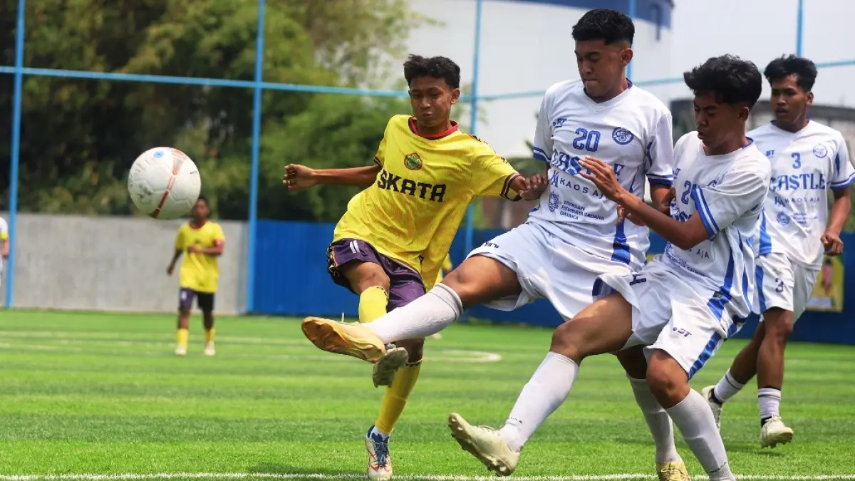 LAGA PERDANA: Dua penggawa SMAN 1 Puri (kostum putih) berusaha merebut bola dari pemain Tamansiswa Mojokerto di laga babak 16 besar. Pertandingan tersebut dimenangkan tim Tamansiswa Mojokerto lewat adu penalti dengan skor 3-2. (SOFAN KURNIAWAN/RADAR MOJOKERTO)