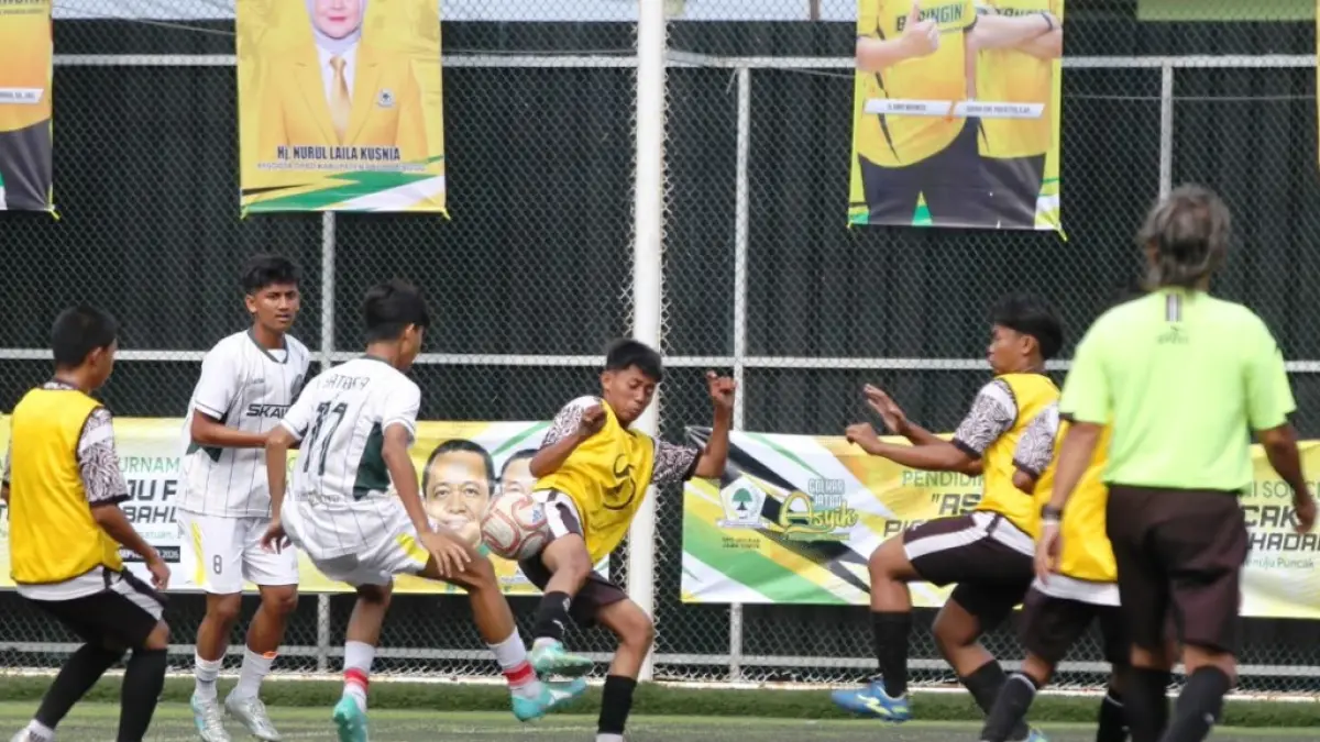 KETAT: Penggawa SMAN 4 Pasuruan (kostum putih) berebut bola dengan pemain SMKS Untung Suropati Pasuruan di babak 16 besar. (Mukhamad Zubaidilah/Radar Bromo)