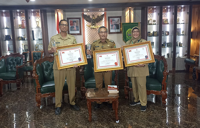 RAIH PENGHARGAAN: Bupati Bantul Abdul Halim Muslih saat menunjukkan penghargaan atas inovasi Simantap Sejagat dan Gelimasjiwo.