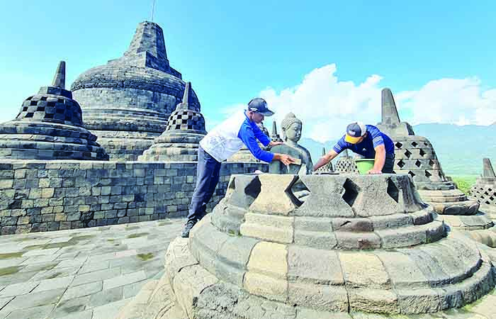 RERESIK: Para pekerja tampak membersihkan bebatuan candi dari lumut maupun mikroorganisme lain. Baik secara kering maupun basah.