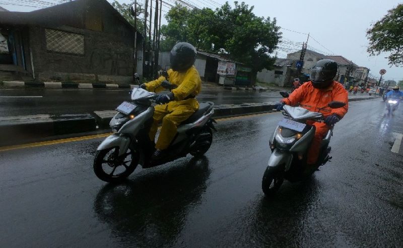 Pemotor mengenakan jas hujan. (website/Carmudi)