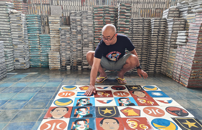 KREATIF: Winarno tengah memamerkan motif logo partai politik (parpol) dan sketsa wajah capres di industri pembuatan tegel Win&nbsp;Art Solution, Dusun Ponggol, Tamanagung, Muntilan.