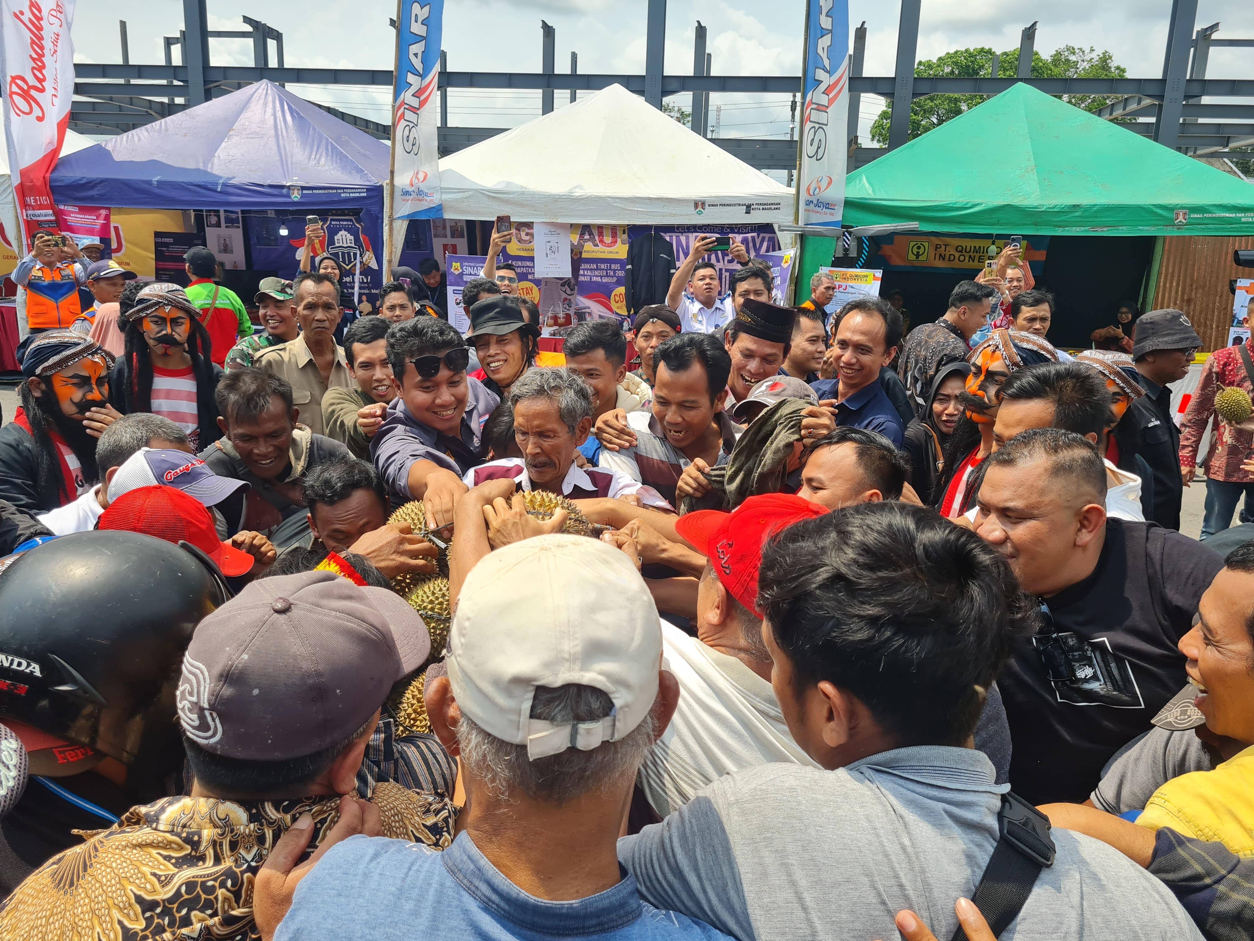 Warga berebut gunungan durian dalam sosialisasi Gerakan Nasional Kembali ke Angkutan Umum di Terminal Tipe A Tidar Magelang Kamis (7/12)
