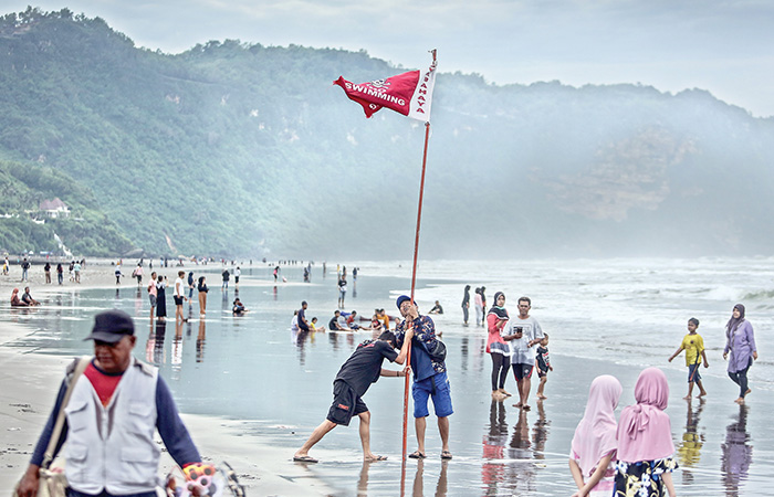 SIAGA: Petugas Dit Polair Polda DIJ memasang bendera bahaya berenang di kawasan pesisir pantai Parangtritis Minggu (1/1). Selama liburan malam pergantian awal tahun lalu, Pantai Parangtritis dikunjung