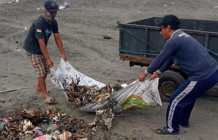 PENANGANAN: Petugas membersihkan sampah yang ditinggalkan wisatawan di Pantai Parangtritis.