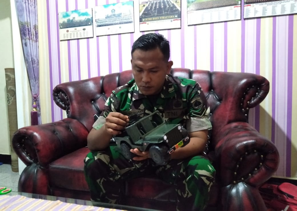 : Serda TNI Eka Mardiyanto Anggota Kodim 0709/Kebumen memegang miniatur kendaraan tempur jenis Jeep Willys yang dibuat dari barang rongsok.