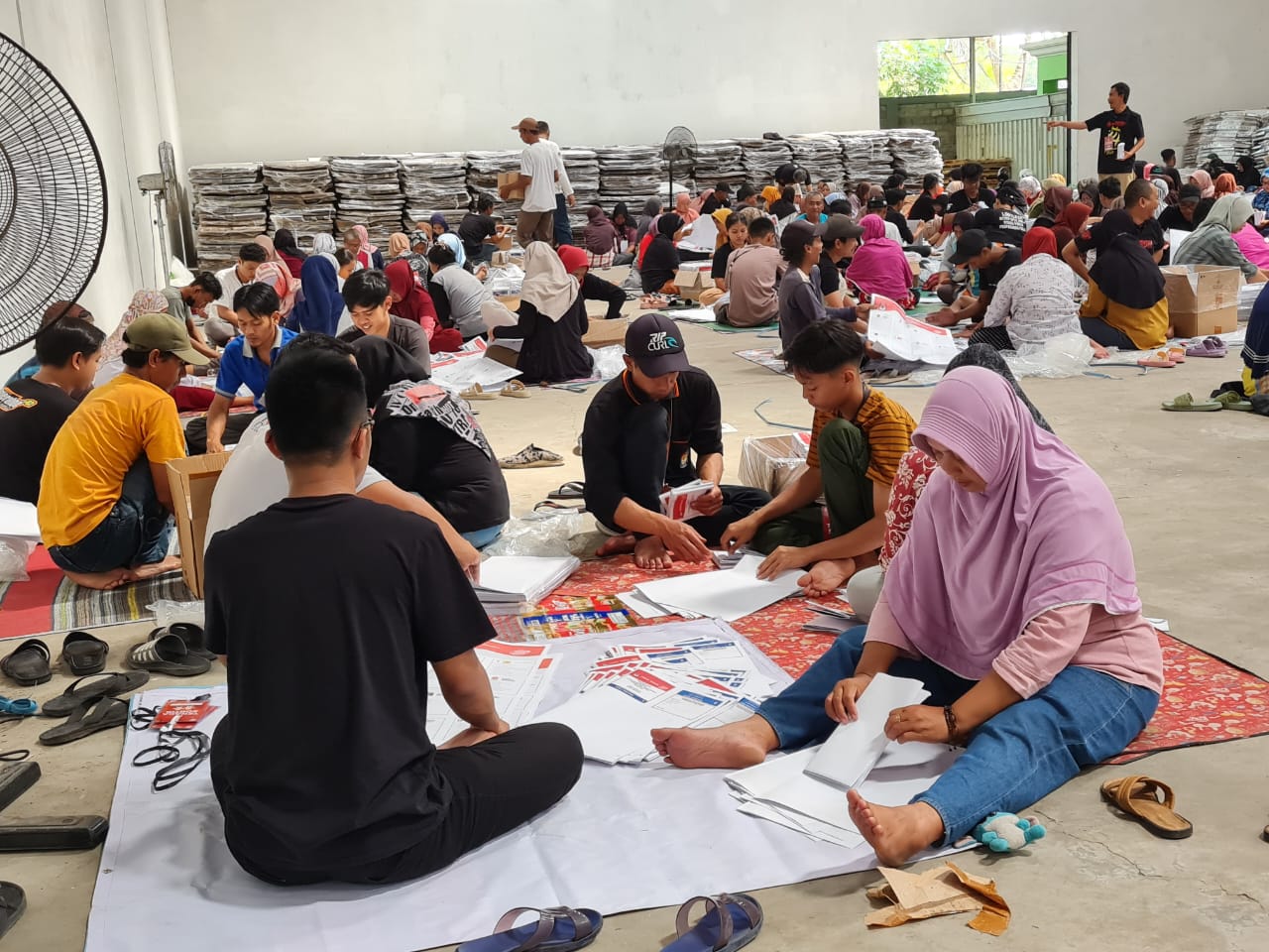 KOMPAK: Para warga tampak melipat surat suara di gudang logistik KPU yang berada di Tamanagung, Muntilan.