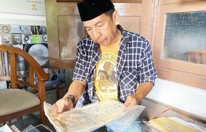 Alex Pracaya menunjukkan salah satu koleksi  desain visual zaman dulu.