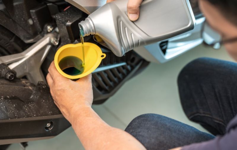 Ilustrasi seorang pria menggantoi oli motornya. Kapan waktu yang tepat untuk mengganti oli motor?