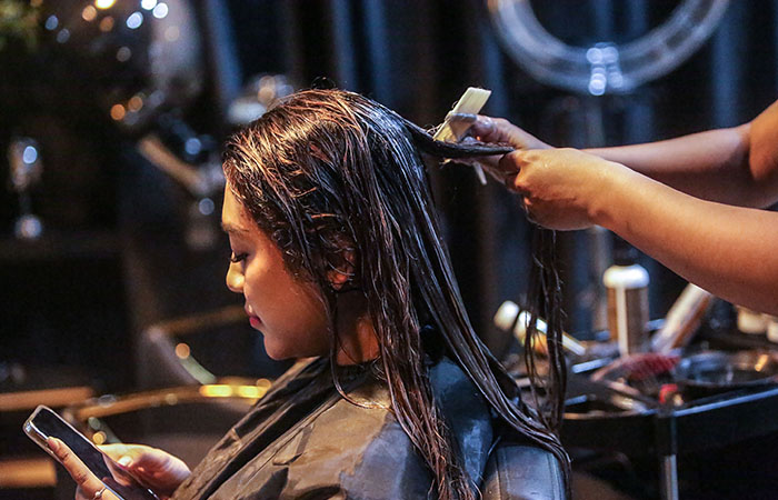 PROSES: Penata rambut di Medua Hair Salon saat mengoleskan krim keratin kepada konsumen kemarin (26/1). Rambut kemudian akan dikeringkan dan dicuci kembali untuk selanjutnya dicatok.