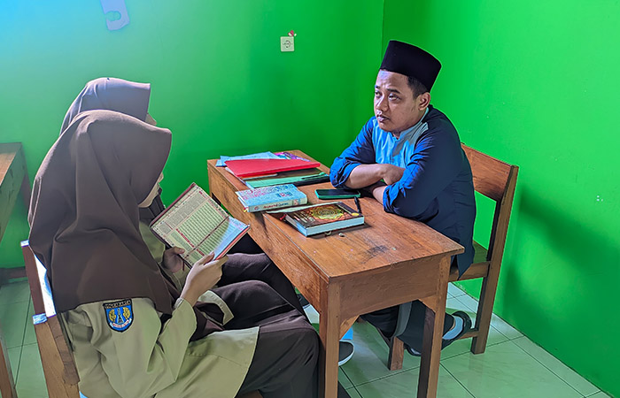 KHUSYUK: Guru mata pelajaran (mapel) Tahfidz Madamusba Khafidz Makmun saat membimbing peserta didik membaca dan menghafal Alquran belum lama ini.