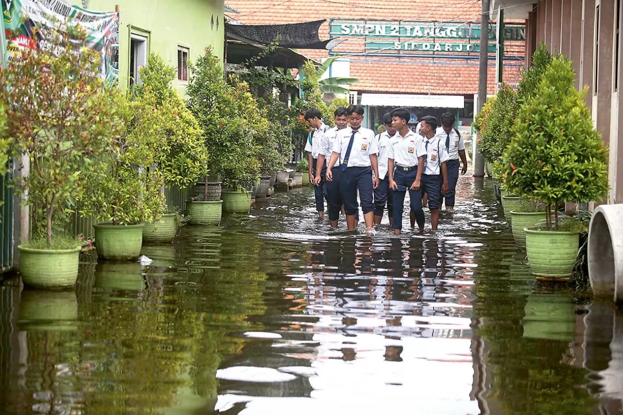 Sebagian murid SMPN 2 Tanggulangin yang tetap masuk ke sekolah ketika banjir menggenangi jalan dan sekolah mereka