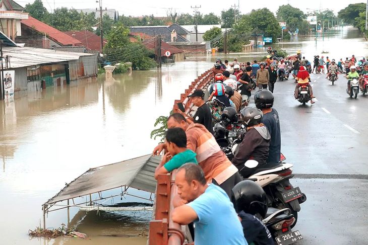 AKSES TERGANGGU: Tanggul Sungai Wulan di Duku Norowito, Desa Ketajung, Kecamatan Karanganyar, Demak, jebol, Minggu (17/3). Akibatnya, jalan pantura Demak-Kudus tak bisa dilalui karena banjir.