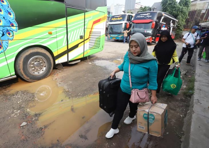 Pemudik menunggu bus yang akan membawa mereka ke kampung halaman.