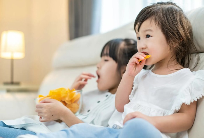 ilustrasi anak-anak yang sedang mengonsumsi ultra processed food/makanan olahan dengan gula berlebih.