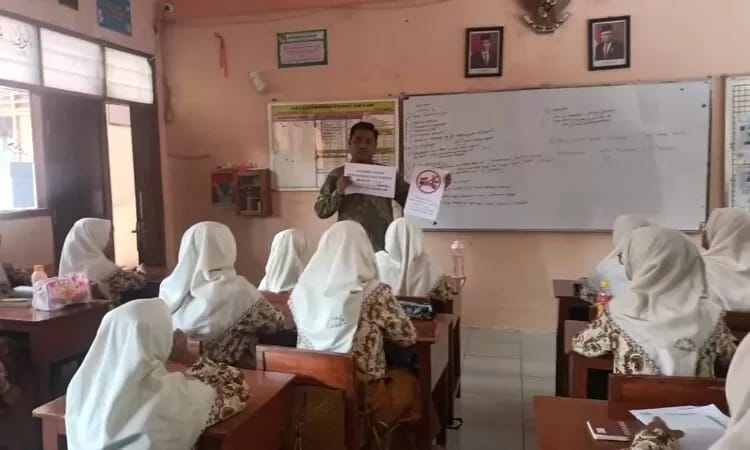 Kepala SMPN 1 Gresik, Berry Avita Prasetya sedang melakukan sosialisasi larangan penggunaan sepeda listrik ke sekolah bagi siswa.