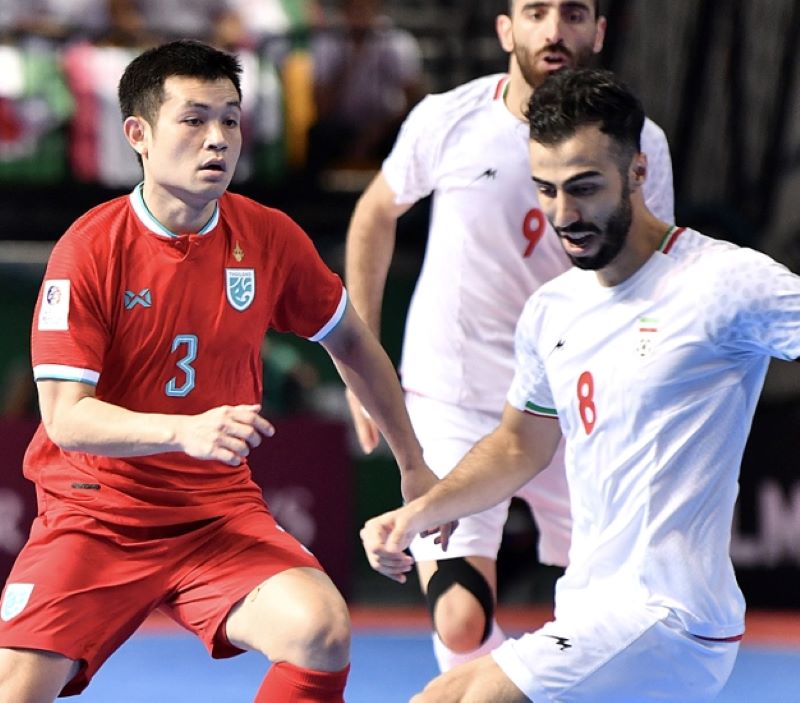 Pemain Thailand dan iran sedang merebut bola.