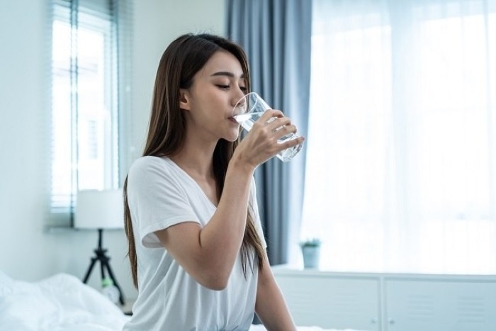 ilustrasi minum air hangat di pagi hari.