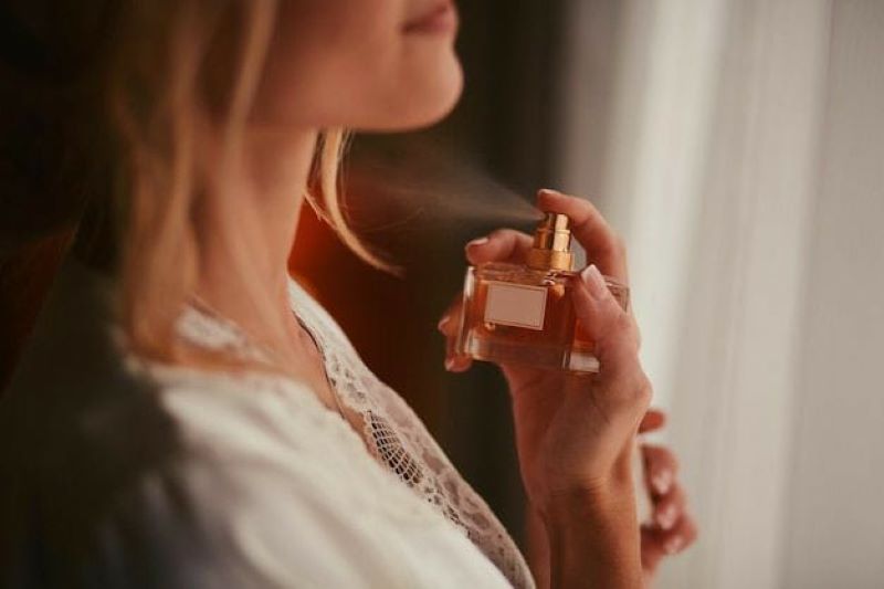 Close-up mulher pulverizando parfume.