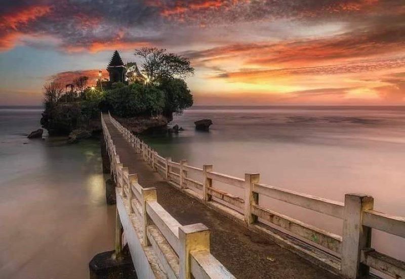 Pantai Balekambang yang dikelilingi oleh cahaya sunset.