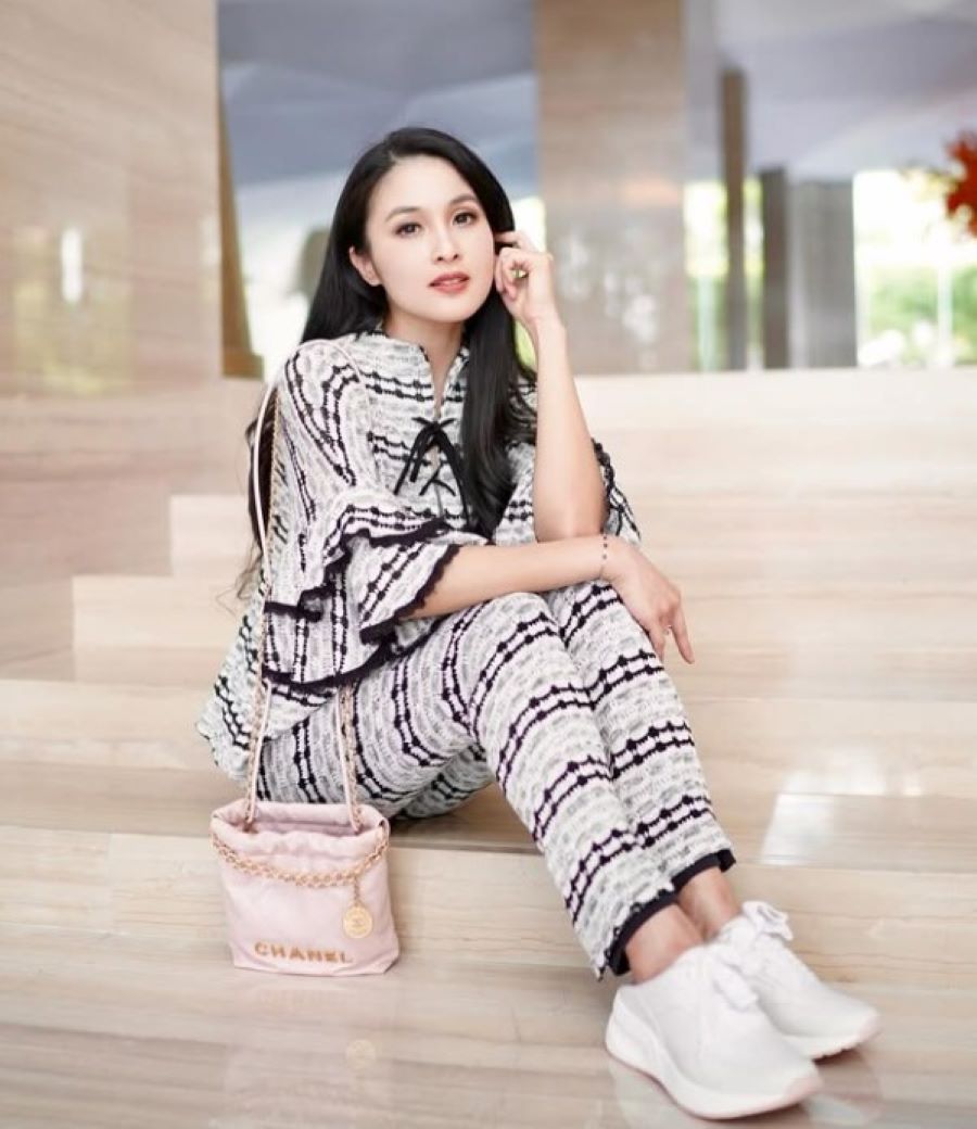 Sandra Dewi berfoto menggunakan tas branded.