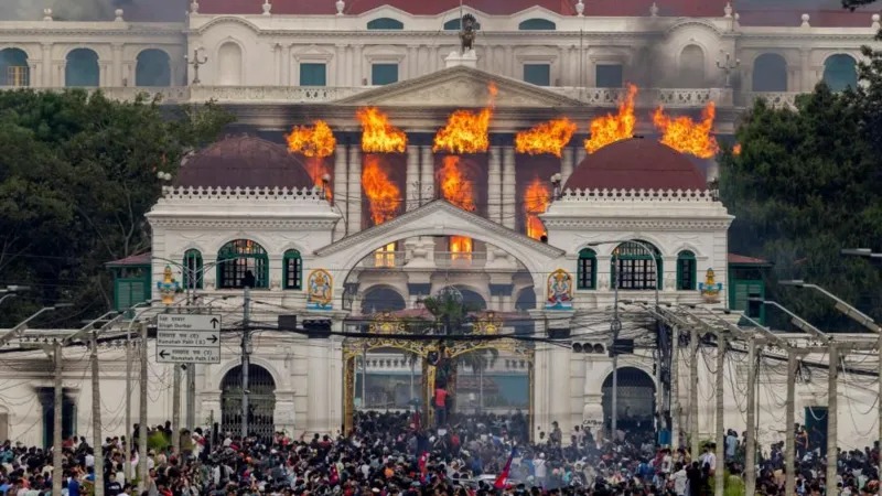 Api dan asap membumbung dari Istana Singha Durbar, yang menampung gedung-gedung pemerintahan dan parlemen, saat para demonstran menyerbu kompleks tersebut di Kathmandu.