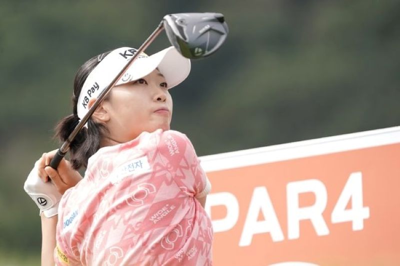 Pegolf mengayunkan stik golf.