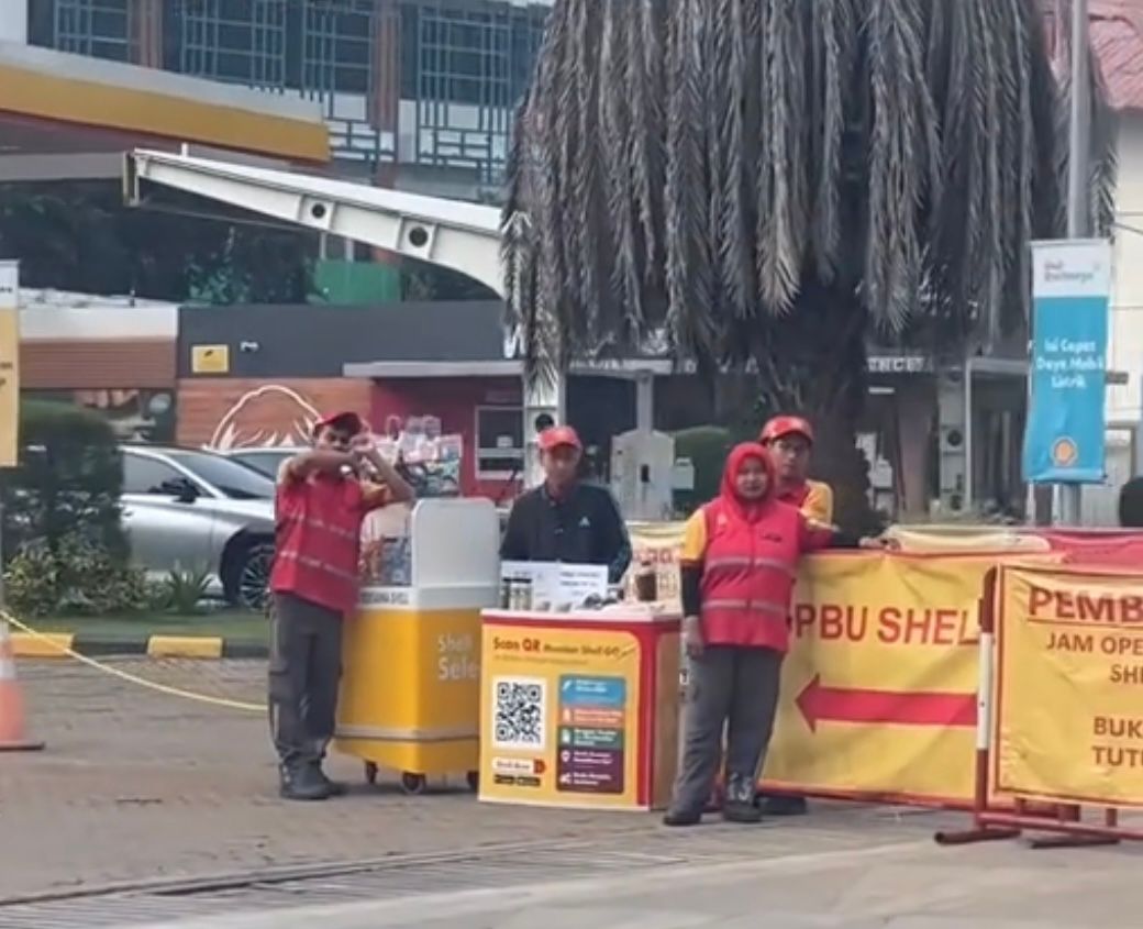 Ilustrasi karyawan SPBU Shell sedang jualan makanan dan minuman ringan.